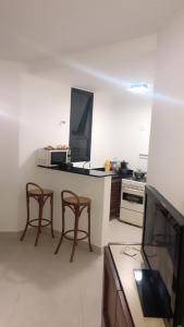 una cucina con 2 sedie e una scrivania con TV di Apartamento Copacabana sistema Apart-hotel a Rio de Janeiro