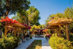 a garden with wooden pergolas filled with flowers at DM Hoteles Mossone - Ica in Ica