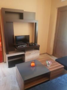 a living room with a tv and a coffee table at ЕКО БУНГАЛА in Trŭn