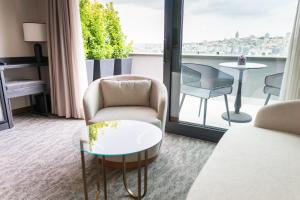 a room with a chair and a table and a balcony at MEG HOTEL in Istanbul