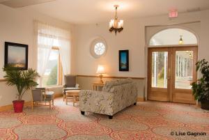 a living room filled with furniture and a large window at Hotel Tadoussac in Tadoussac