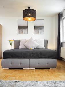 Bett im Wohnzimmer mit Lampe in der Unterkunft flex living - Apartment Nikolai in Leipzig