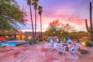 un patio con sillas, una mesa y una piscina en Hacienda Panorama Estate, en Tucson