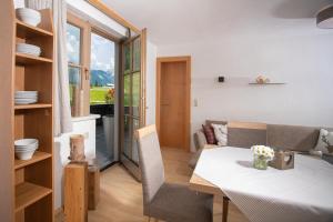uma cozinha e sala de jantar com uma mesa branca e cadeiras em Fewo an der Seepromenade em Pertisau