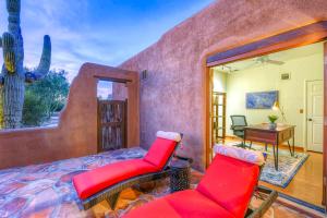 1 dormitorio con 1 cama roja y 2 sillas rojas en Hacienda Panorama Estate, en Tucson