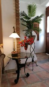 a table with a lamp and a vase of flowers on it at Casa Magica in Olhão