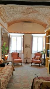 a living room with two chairs and two windows at Casa Magica in Olhão