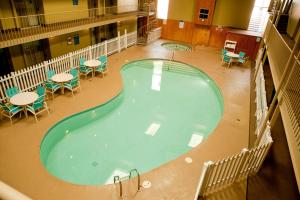 an overhead view of a large swimming pool with tables and chairs at Ramada by Wyndham Marquette in Marquette