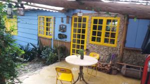 un patio con mesa y sillas frente a una casa en Chales Bamboo Jungle, en Petrópolis