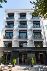 un bâtiment blanc avec des tables et des chaises devant lui dans l'établissement MEG HOTEL, à Istanbul