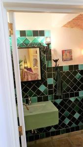 a bathroom with a green sink and a mirror at Casa Magica in Olhão