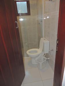a bathroom with a toilet and a glass shower at Chalés Marazul Toninhas in Ubatuba