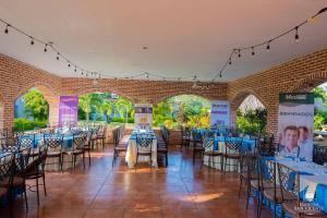 a room with tables and chairs and a brick wall at Hacienda San Vicente in Flores