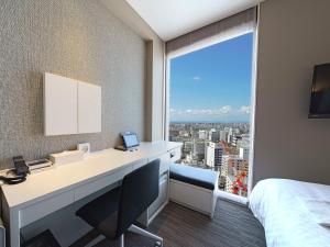 a hotel room with a desk and a large window at Meitetsu Inn Nagoyaeki Shinkansenguchi in Nagoya +49 photos