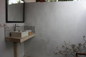 a bathroom with a sink and a mirror on a wall at Radya Homestay in Nusa Lembongan