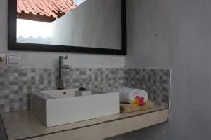 a bathroom with a white sink and a mirror at Radya Homestay in Nusa Lembongan