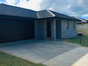 a house with a garage in front of it at Stunning Modern Retreat in Hastings