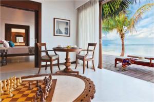 una habitación con un tablero de ajedrez y una habitación con un dormitorio en The Residence Maldives, en Gaafu Alifu Atoll