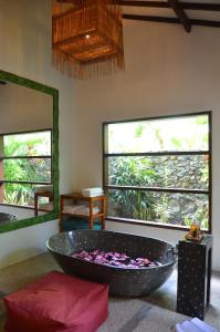a large tub in a room with two windows at Cocotinos Sekotong Lombok in Sekotong