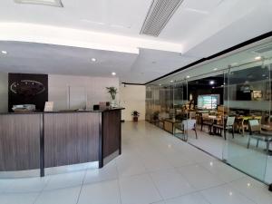 a lobby with a restaurant with tables and chairs at Golden Valley Hotel in Cebu City