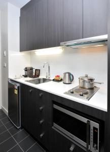 a kitchen with two pots and a sink and a stove at Mercure Melbourne Therry Street in Melbourne