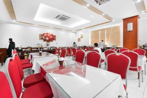 a dining room with red chairs and tables and people at Khách Sạn Sao in Hanoi