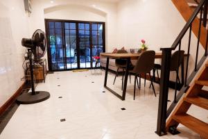 Una habitación con una mesa y sillas y una escalera. en Lisa'House, en Bangkok