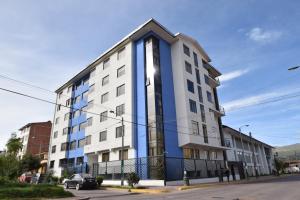 un edificio blanco y azul en una calle en Elite Apartment, en Cusco