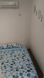 - une chambre dotée d'un lit avec une couette bleue aux motifs floraux dans l'établissement The Container, à Labuan Bajo