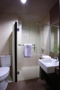 La salle de bains est pourvue de toilettes, d'un lavabo et d'une douche. dans l'établissement Rasuna Mansion, à Jakarta