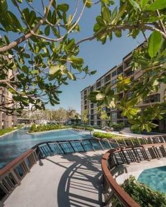 a swimming pool with chairs and a building at Rain condo ChaAm HuaHin by AY B311 in Cha Am