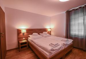 1 dormitorio con 1 cama grande con sábanas y almohadas blancas en Apartamenty ZYGFRYD 28C/3/1, en Bystrzyca Kłodzka