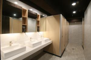 a bathroom with three sinks and a shower at Mu Pinju Hotel in Taichung
