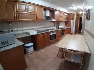 a kitchen with wooden cabinets and a table in it at Casa do Pelourinho in Vouzela