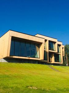 a building with large windows on top of a green field at Aurora Villa in Fairbanks