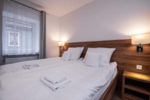 sypialnia z dużym białym łóżkiem z białymi poduszkami w obiekcie Apartamenty ZYGFRYD 28C/3/2 w mieście Bystrzyca Kłodzka