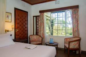 Jacaranda Lake Elementaita Lodge客房内的一张或多张床位