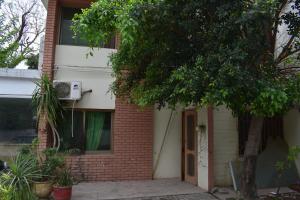 a brick house with a tree in front of it at Tulip guesthouse in Islamabad