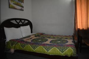 a bed with a quilt on it in a bedroom at Tulip guesthouse in Islamabad +4 photos