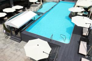 uitzicht op een groot zwembad met parasols bij WesternLife Hotel in Iksan