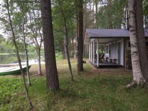 a small house in the woods next to a boat at saunamökki Rauhala,LaatuLomat in Juva +10 photos