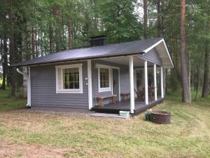a small house with a porch in the woods at saunamökki Rauhala,LaatuLomat in Juva
