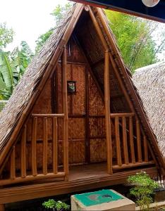 une petite maison avec un toit de chaume et un escalier dans l'établissement BigBlue Waters Resort, à Liloan