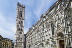 a large building with a clock tower next to it at Great Apts Few Steps to The Duomo in Florence