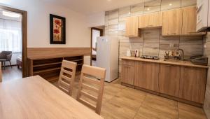 a kitchen with a table and a refrigerator at Apartamenty ZYGFRYD 28C 3 6 in Bystrzyca Kłodzka +10 photos