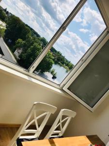 a room with a large window with two chairs and a table at Cozy apartment with lake view in Trakai
