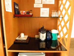 a counter with a coffee maker and cups on it at Sirin Hotel Hua Hin in Hua Hin