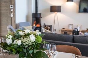 a vase of flowers on a table with a fireplace at Canyon Lodge by Alpine Resorts in Saint-Bon-Tarentaise