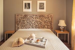 a bed with a tray with a tea set on it at Lake & Library Hotel in Ignalina