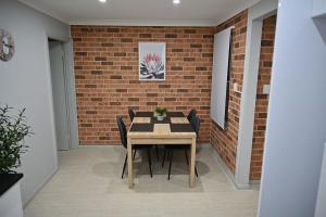 a dining room with a table and a brick wall at Bowman's Place in Guildford